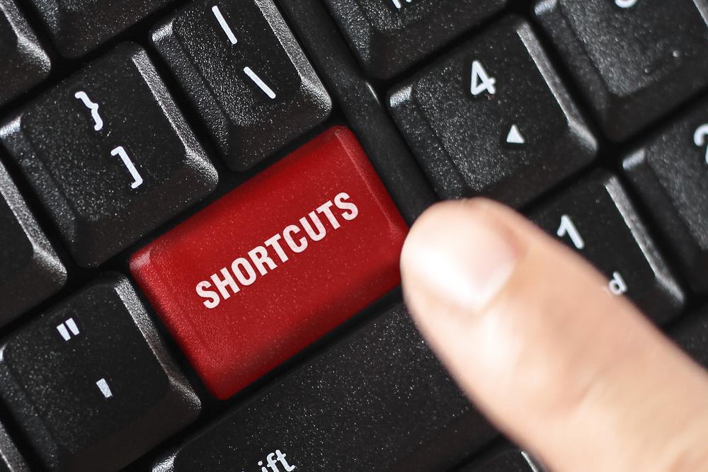 A finger pressing a shortcut button
Description automatically generated