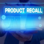 A man holds a tablet that has a blue light shining from it and the words "Product Recall" above it.